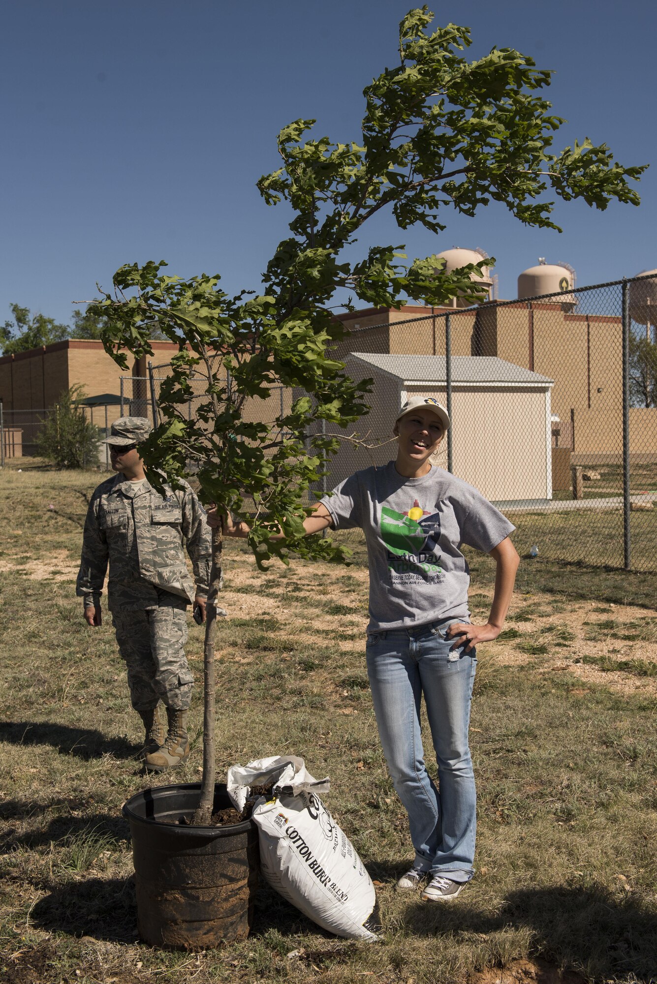 Ola Kirk, 27th Special Operations Civil Engineer Squadron Environmental Office, poses for a photo with the ceremonial tree during the Arbor Day and Earth Day tree planting ceremony at the Youth Center on Cannon Air Force Base, NM, April 19, 2017. With the planting of the tree, April 19 was deemed Arbor Day for Cannon, as decreed by Col. Douglas Gilpin, 27th Special Operations Mission Support Group commander. (U.S. Air Force photo by Staff Sgt. Michael Washburn/Released)