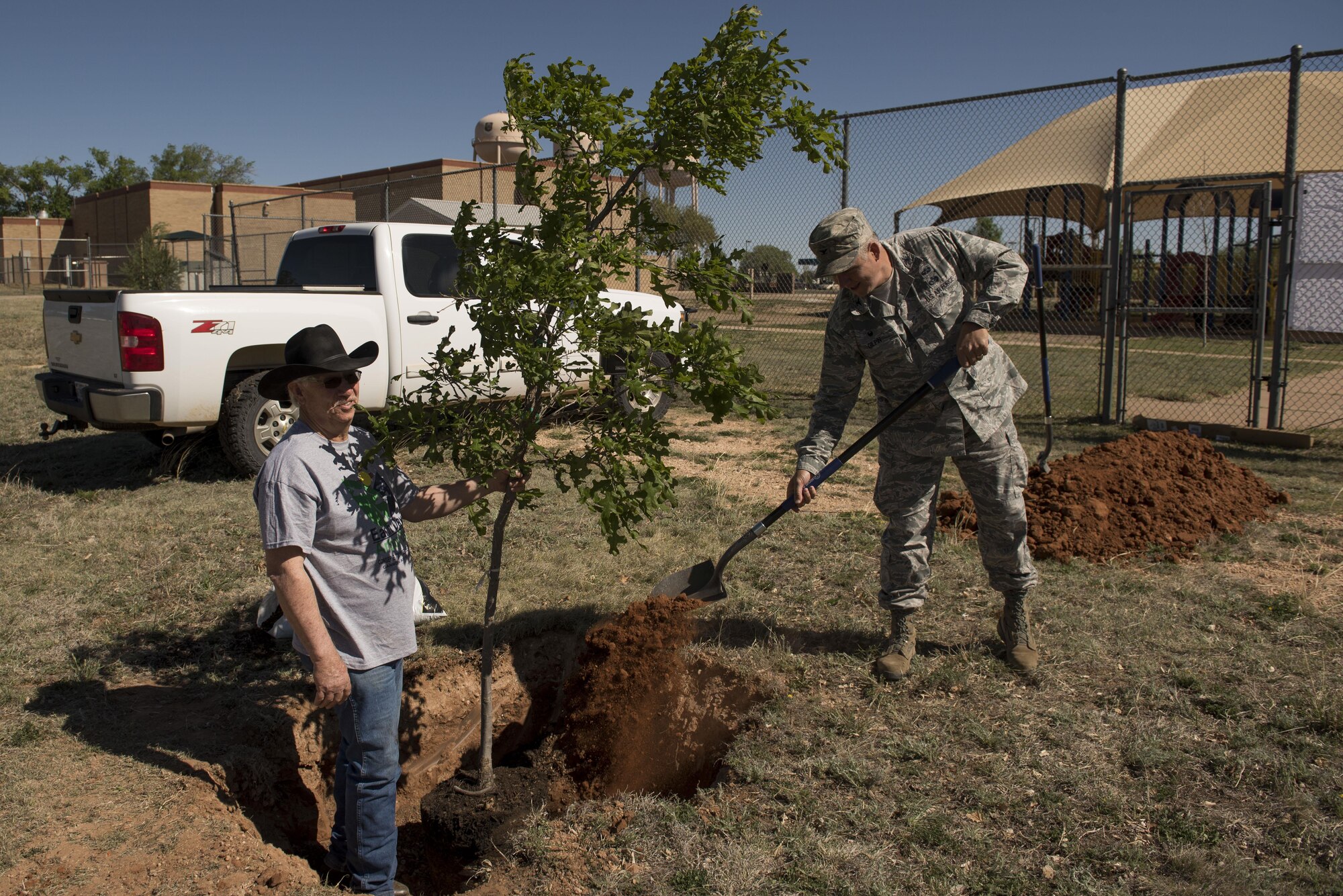 Col. Douglas Gilpin, 27th Special Operations Mission Support Group commander, throws the first mound of dirt during the Arbor Day and Earth Day tree planting ceremony at the Youth Center on Cannon Air Force Base, NM, April 19, 2017. The tree planting was one of three events themed after Earth Day and also Arbor Day, which was decreed to be April 19 at Cannon by Gilpin. (U.S. Air Force photo by Staff Sgt. Michael Washburn/Released)