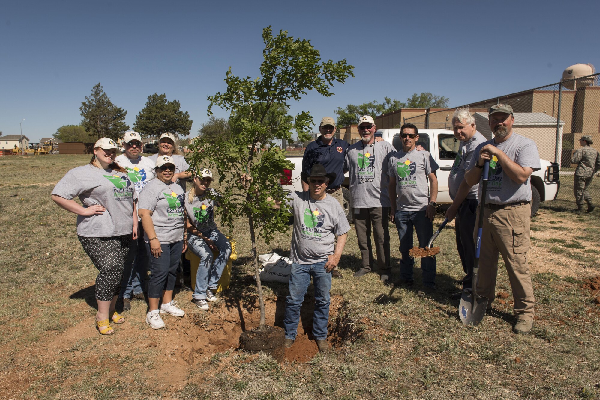 Members of the 27th Special Operations Civil Engineer Squadron Environmental Office pose for a photo after the Arbor Day and Earth Day tree planting ceremony at the Youth Center on Cannon Air Force Base, NM, April 19, 2017. Small Afghan Pine trees, along with t-shirts, were available for anyone to take that came to the ceremony. (U.S. Air Force photo by Staff Sgt. Michael Washburn/Released)
