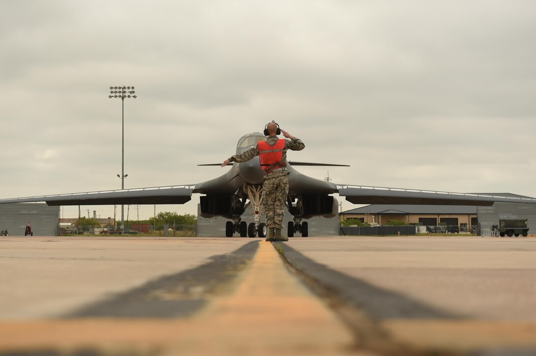 U.S. Air Force Airman 1st Class Chance Barfield, 7th Aircraft Maintenance Squadron crew chief, marshals Maj. Gen. Thomas Bussiere, 8th Air Force commander, toward the runway for his B-1B Lancer familiarization flight at Dyess Air Force Base, Texas, April 19, 2017. During his visit, Bussiere, was given the opportunity to fly in the B-1 to understand the bomber’s critical role in security and deterrence while at home and abroad. (U.S. Air Force photo by Airman 1st Class Emily Copeland)