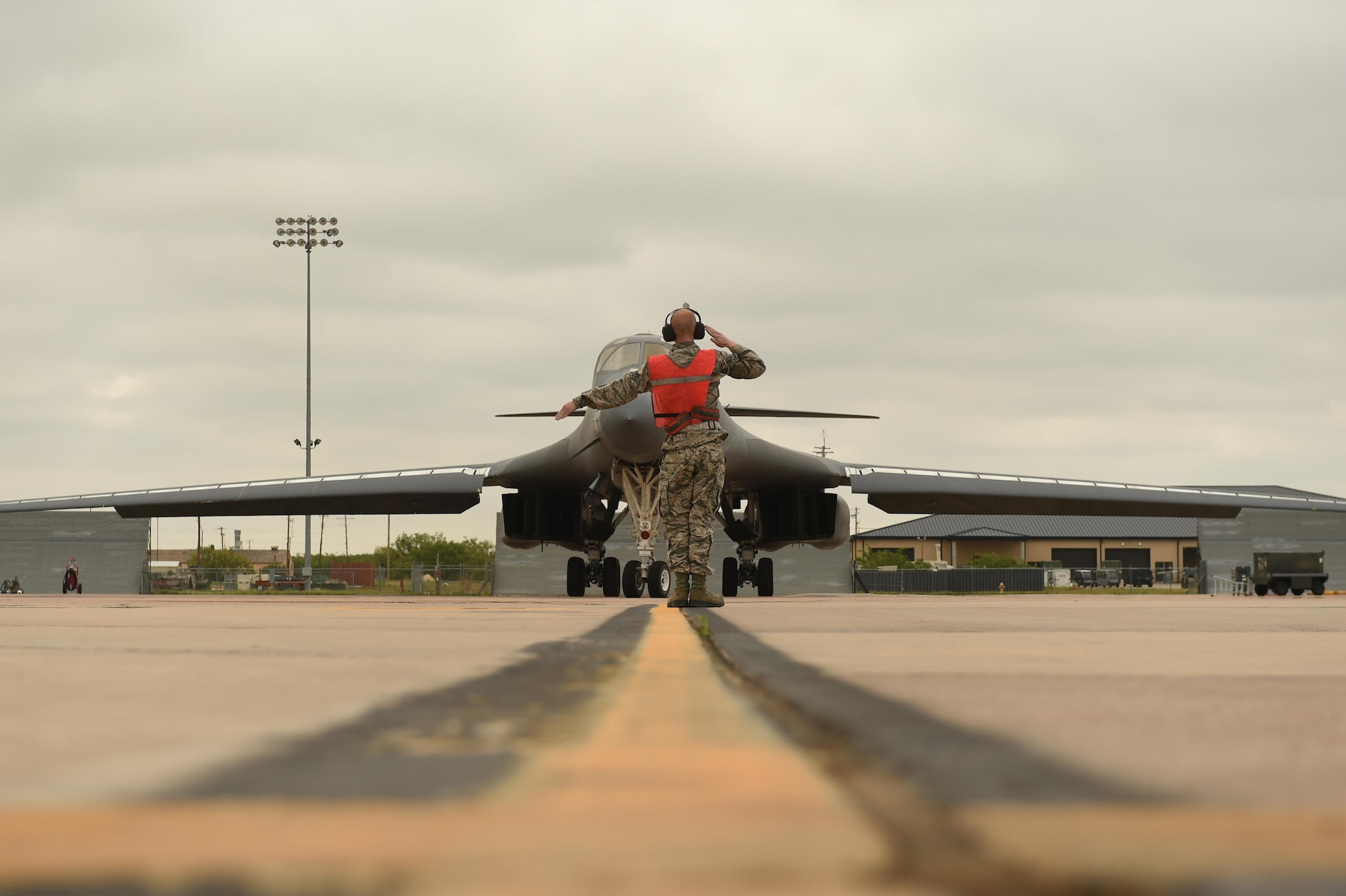 U.S. Air Force Airman 1st Class Chance Barfield, 7th Aircraft Maintenance Squadron crew chief, marshals Maj. Gen. Thomas Bussiere, 8th Air Force commander, toward the runway for his B-1B Lancer familiarization flight at Dyess Air Force Base, Texas, April 19, 2017. During his visit, Bussiere, was given the opportunity to fly in the B-1 to understand the bomber’s critical role in security and deterrence while at home and abroad. (U.S. Air Force photo by Airman 1st Class Emily Copeland)