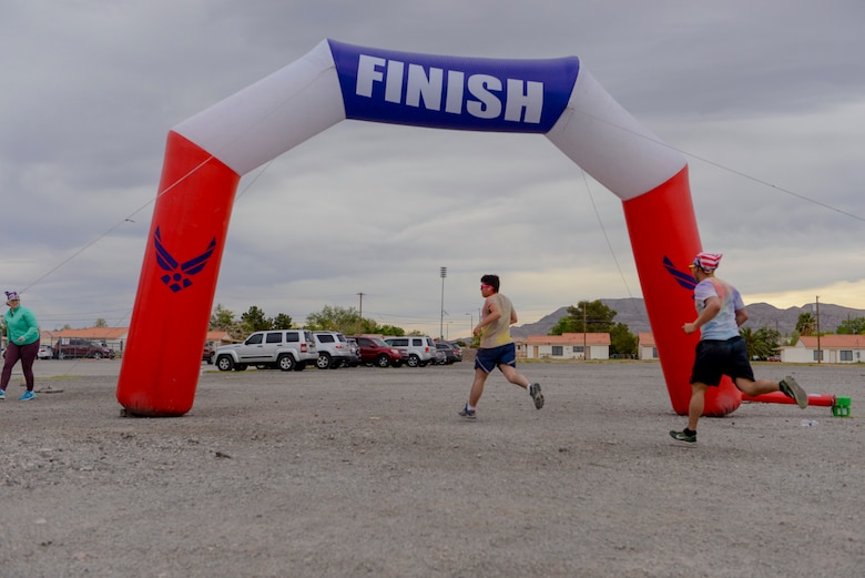 Airmen cross the finish line at the 5k Color Run/Walk, April 7, 2017, at Nellis Air Force Base, Nev. Multiple base agencies set up stands at the finish line to promote awareness and offer further information for Airmen and their families. (U.S. Air Force photo by Airman 1st Class Andrew D. Sarver/ Released)

