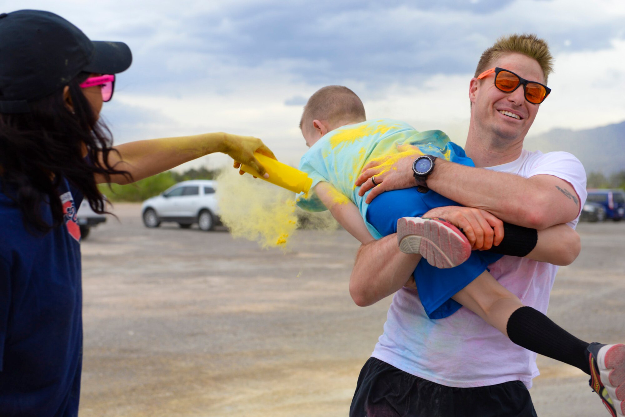 Master Sgt. Briand Daubert, a 414th Combat Training Squadron personnel recovery division member, carries his son to get covered with yellow powder during the 5k Color Run/Walk, April 7, 2017, at Nellis Air Force Base, Nev. Daubert and his family participated in the run which promoted Comprehensive Airmen Fitness. (U.S. Air Force photo by Airman 1st Class Andrew D. Sarver/ Released)



