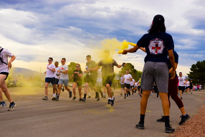 Staff Sgt. Dominique Lindsey, 99th Medical Operations Squadron mental health technician, showers Airmen with yellow powder at the 5k Color Run/Walk, April 7, 2017, at Nellis Air Force Base, Nev. The 5k Color Run/Walk participants were doused with several colors that represented different base agencies around Nellis AFB.
(U.S. Air Force photo by Airman 1st Class Andrew D. Sarver/ Released)



