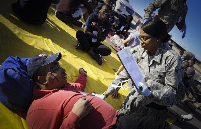 An Airman from the 99th Medical Group checks on a simulated victim during the Major Accident Response Exercise at Nellis Air Force Base, Nev., April 13, 2017. The simulated wounded were separated into three categories based on severity of injury in order to treat those with the most life-threatening injuries first. (U.S. Air Force photo by Senior Airman Kevin Tanenbaum/Released)