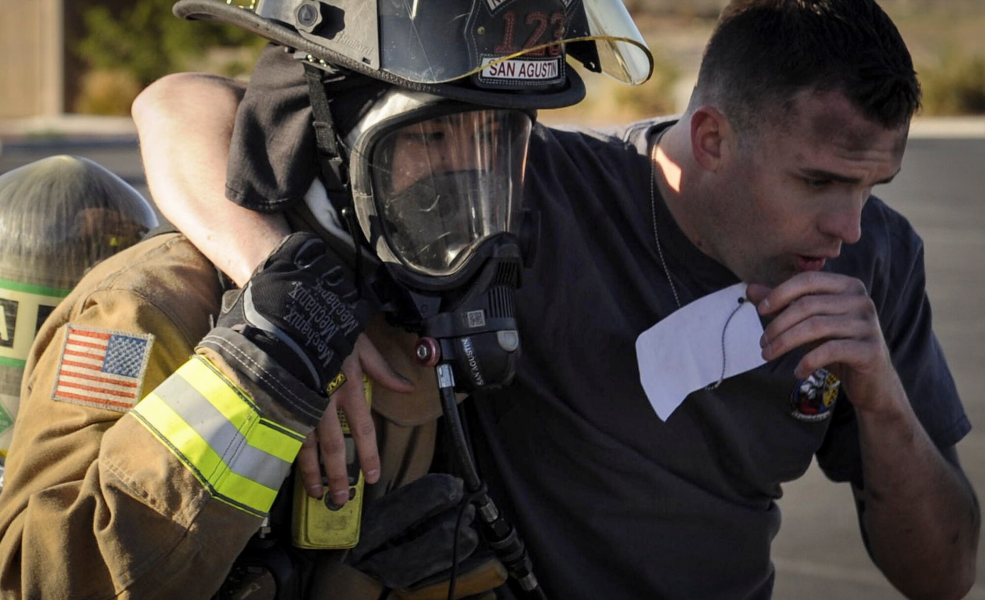 A firefighter from the 99th Civil Engineer Squadron helps a simulated victim to safety during the Major Accident Response Exercise at Nellis Air Force Base, Nev., April 13, 2017. Large-scale exercises allow base agencies to test cooperation and ensure seamless transitions from one agency to another, should an emergency occur on base. (U.S. Air Force photo by Senior Airman Kevin Tanenbaum/Released)
