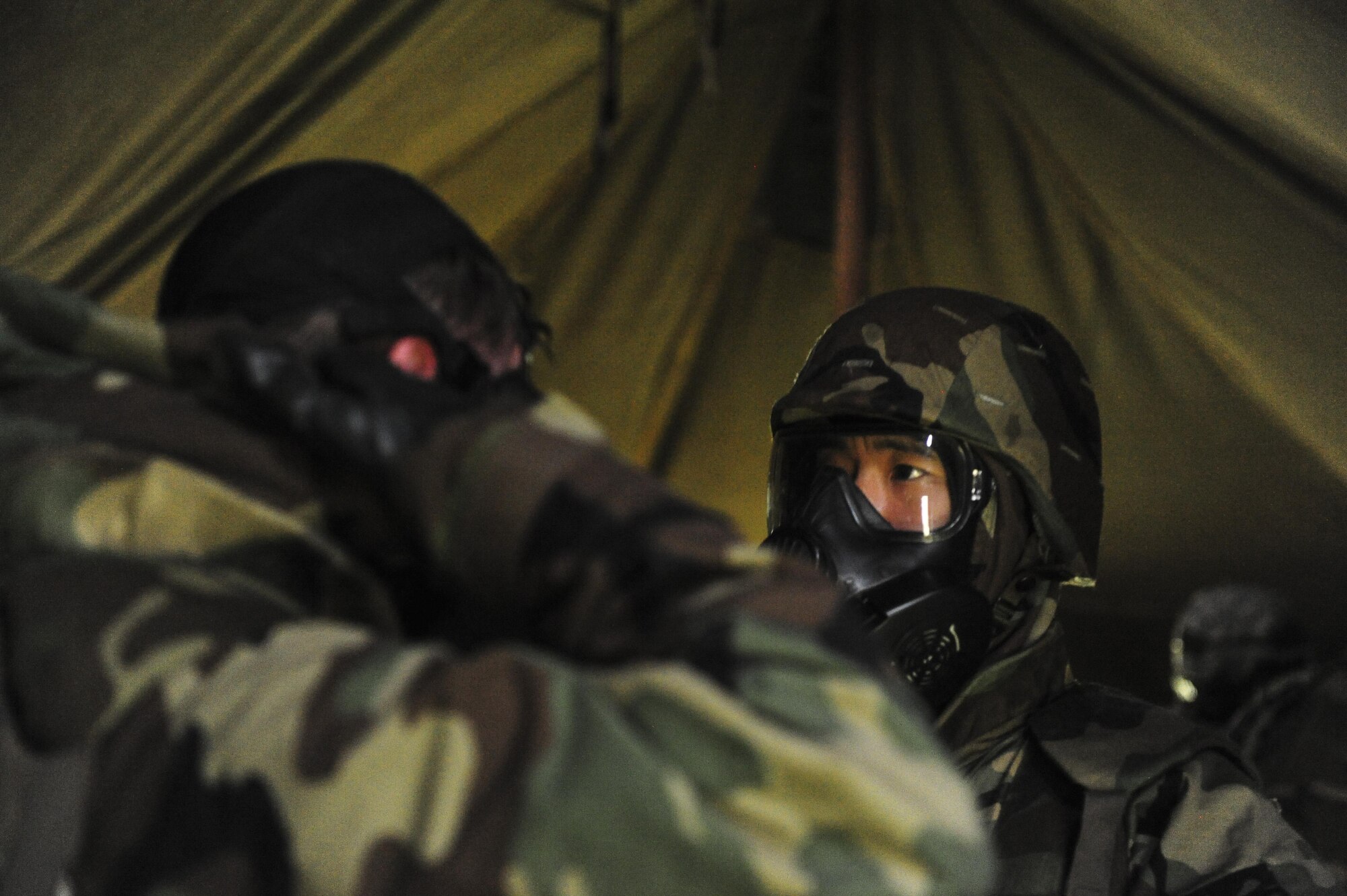 Airmen stationed at Hickam Field check each other's Mission Oriented Protective Posture (MOPP) gear for an exercise scenario during Exercise TROPIC THUNDER 2017 (XTT17), at Wheeler Army Airfield, Hawaii, April 20, 2017.  XTT17 is a two part full spectrum readiness exercise hosted by the 15th Wing to test the individual, organizational and expeditionary readiness of the Airmen stationed at Joint Base Pearl Harbor-Hickam. (U.S. Air Force photo by Tech. Sgt. Heather Redman)