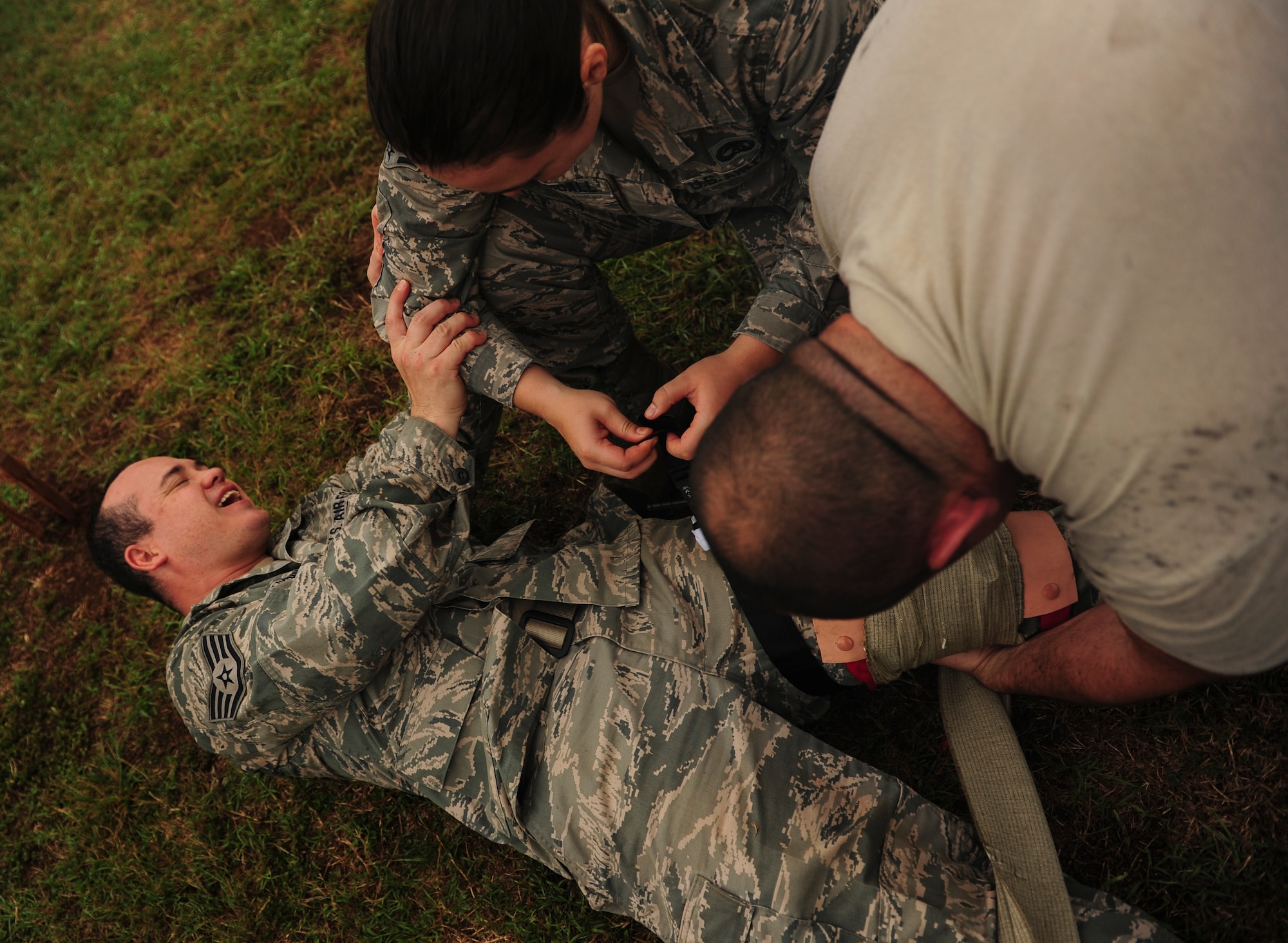 Airmen stationed at Hickam Field simulate self-aid buddy care on each other during Exercise TROPIC THUNDER 2017 (XTT17), at Wheeler Army Airfield, Hawaii, April 20, 2017.  XTT17 is a two part full spectrum readiness exercise hosted by the 15th Wing to test the individual, organizational and expeditionary readiness of the Airmen stationed at Joint Base Pearl Harbor-Hickam. (U.S. Air Force photo by Tech. Sgt. Heather Redman)