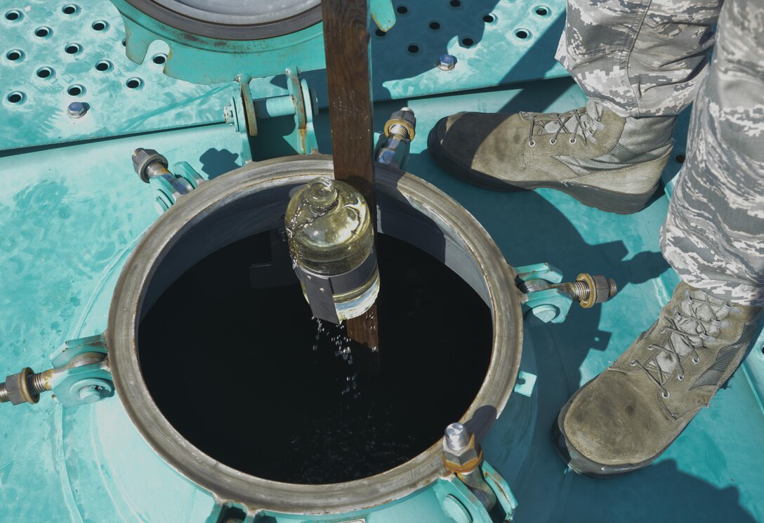Senior Airman Robert Edmonds, 374th Logistics Readiness Squadron fuels laboratory technician, lifts a jar of JP8 fuel from a tank car to perform a visual test of the fuel at Yokota Air Base, Japan, April 19, 2017. Lab members run daily tests on fuel that can take between five minutes and two hours. (U.S. Air Force photo by Staff Sgt. David Owsianka)