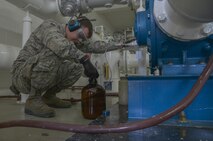 Staff Sgt. David Carson, 374th Logistics Readiness Squadron fuels laboratory NCO in charge, fills a container with a cumulative sample of JP8 fuel from 12 tank cars at Yokota Air Base, Japan, April 19, 2017. The lab ensures the fuel is clean, isn’t mixed with other types of fuel and meets the standards the military puts out. (U.S. Air Force photo by Staff Sgt. David Owsianka)