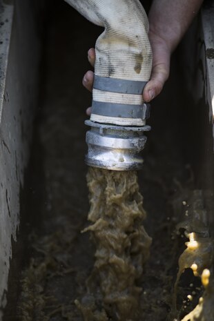 Muddy water flows through a hose and into a drainage ditch during airfield damage and repair training at Marine Corps Air Station Iwakuni, Japan, April 19, 2017. The ADR training required Marines to utilize their skill set to tactically and proficiently fix any anomalies to a simulated damaged airfield. The training focused on becoming more efficient in situations that may require Marines to act in real-world scenarios to maintain the tempo of aircraft operations. (U.S. Marine Corps photo by Lance Cpl. Joseph Abrego)