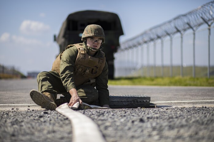 U.S. Marine Corps Lance Cpl. Ryan Miston, a combat engineer with Marine Wing Support Squadron (MWSS) 171, monitors a hose as it pumps water into a drainage ditch during airfield damage and repair training at Marine Corps Air Station Iwakuni, Japan, April 19, 2017. The ADR training required Marines to utilize their skill set to tactically and proficiently fix any anomalies to a simulated damaged airfield. The training focused on becoming more efficient in situations that may require Marines to act in real-world scenarios to maintain the tempo of aircraft operations. (U.S. Marine Corps photo by Lance Cpl. Joseph Abrego)
