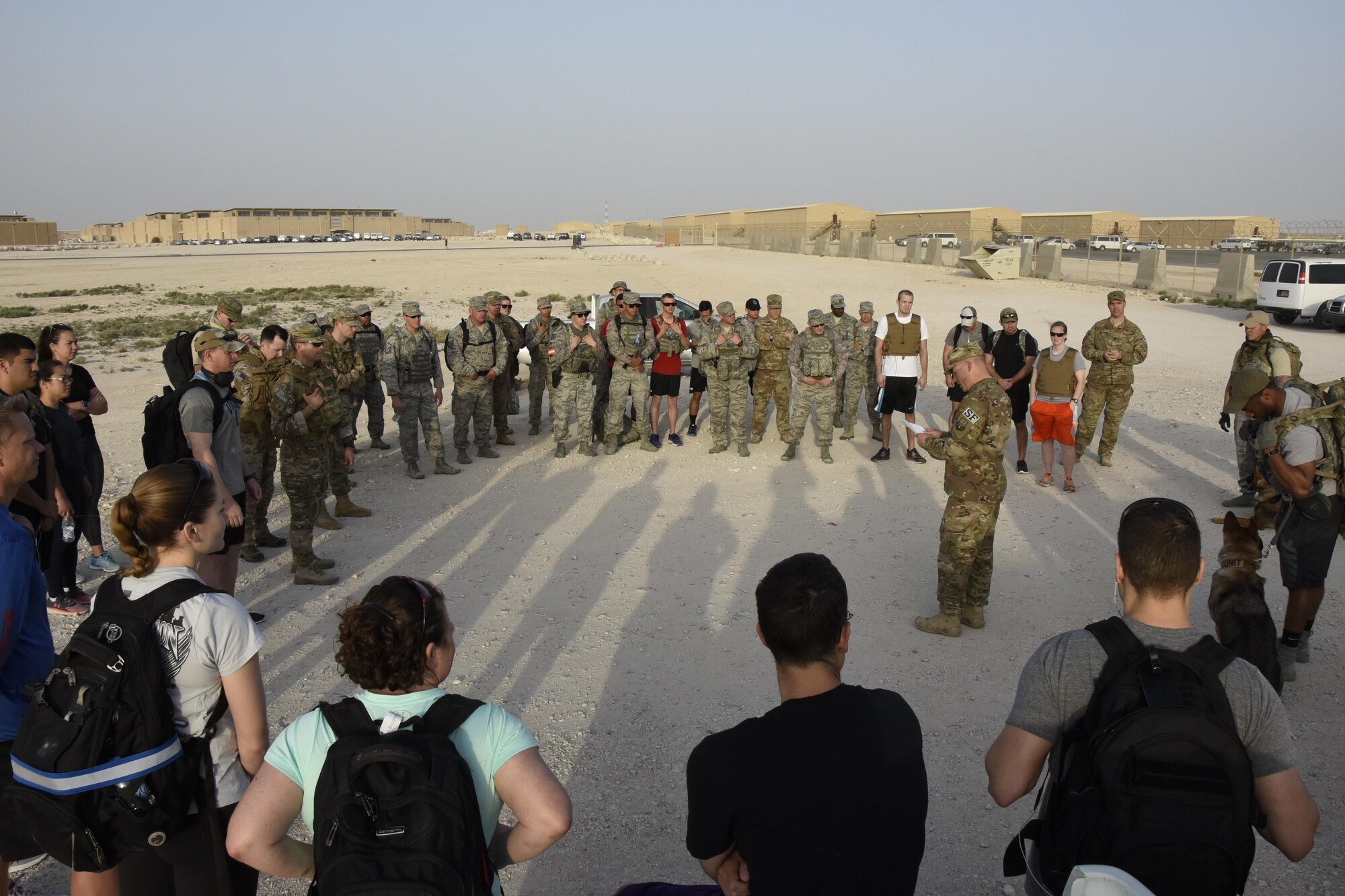 Personnel gather for opening remarks during a military working dog and military working dog handler commemoration ceremony at Al Udeid Air Base, Qatar, April 20, 2017. The commemoration ceremony was followed by a three-mile ruck and was organized to honor fallen handlers and canines.  (U.S. Air Force photo by Senior Airman Cynthia A. Innocenti)