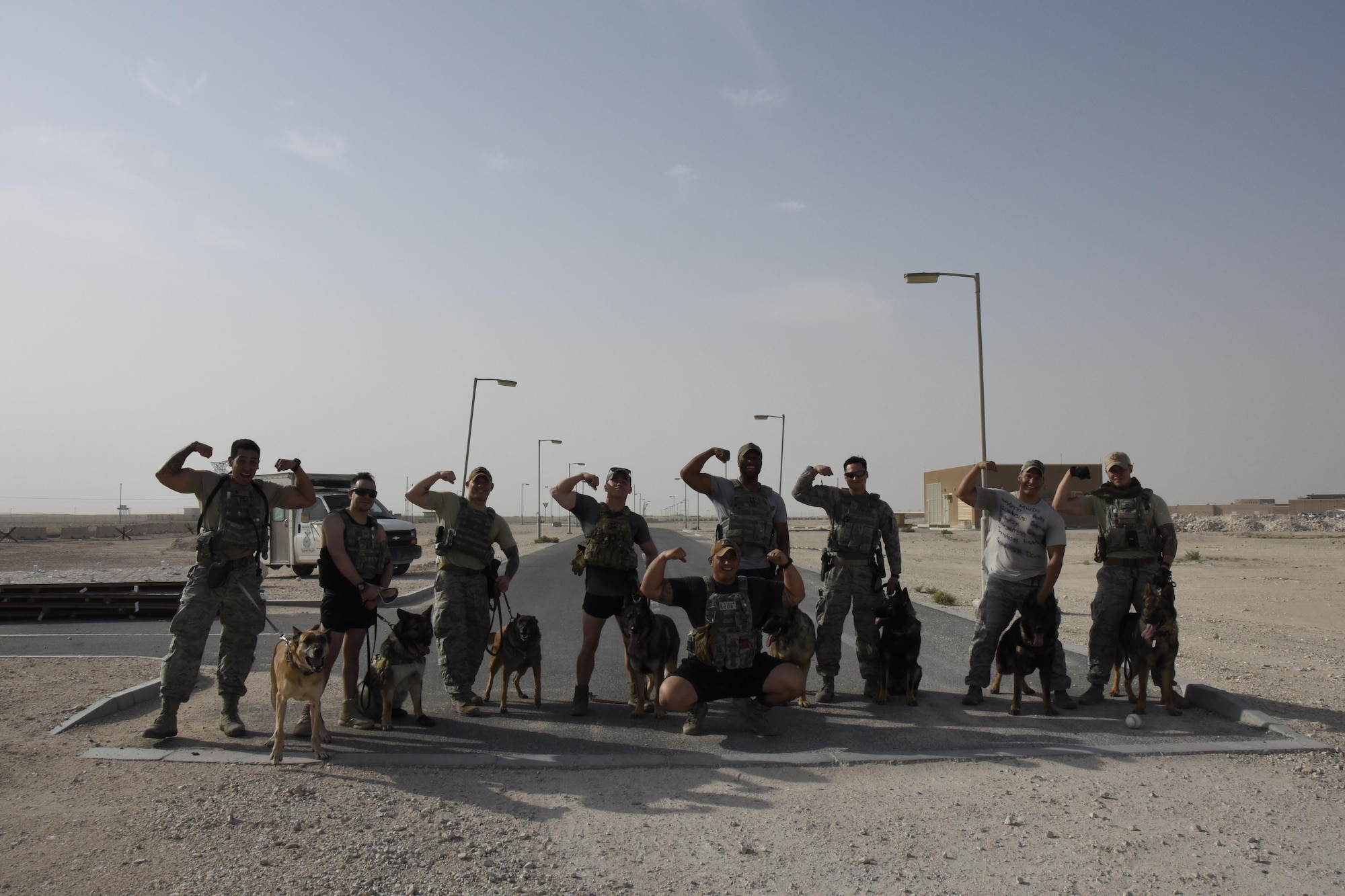 U.S. Air Force Airmen with the 379th Expeditionary Security Forces Squadron Military Working Dog Section pose for a photo after finishing a three-mile ruck at Al Udeid Air Base, Qatar, April 20, 2017. The ruck was organized in conjunction with a commemoration ceremony to honor fallen military working dog handlers and military working dogs. (U.S. Air Force photo by Senior Airman Cynthia A. Innocenti)