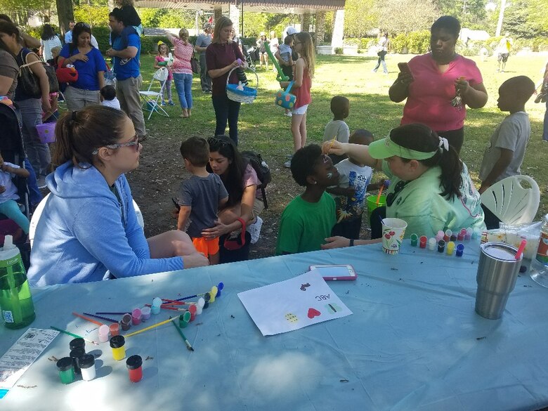 Geotechnical and Structures Laboratory's Sarah Williams takes a break from face painting as Coastal and Hydraulics Laboratory's Robin Dixon paints a bunny face during the WES-ERDC Castle Club Easter Basket Raffle and Easter Egg Hunt event April 1.
