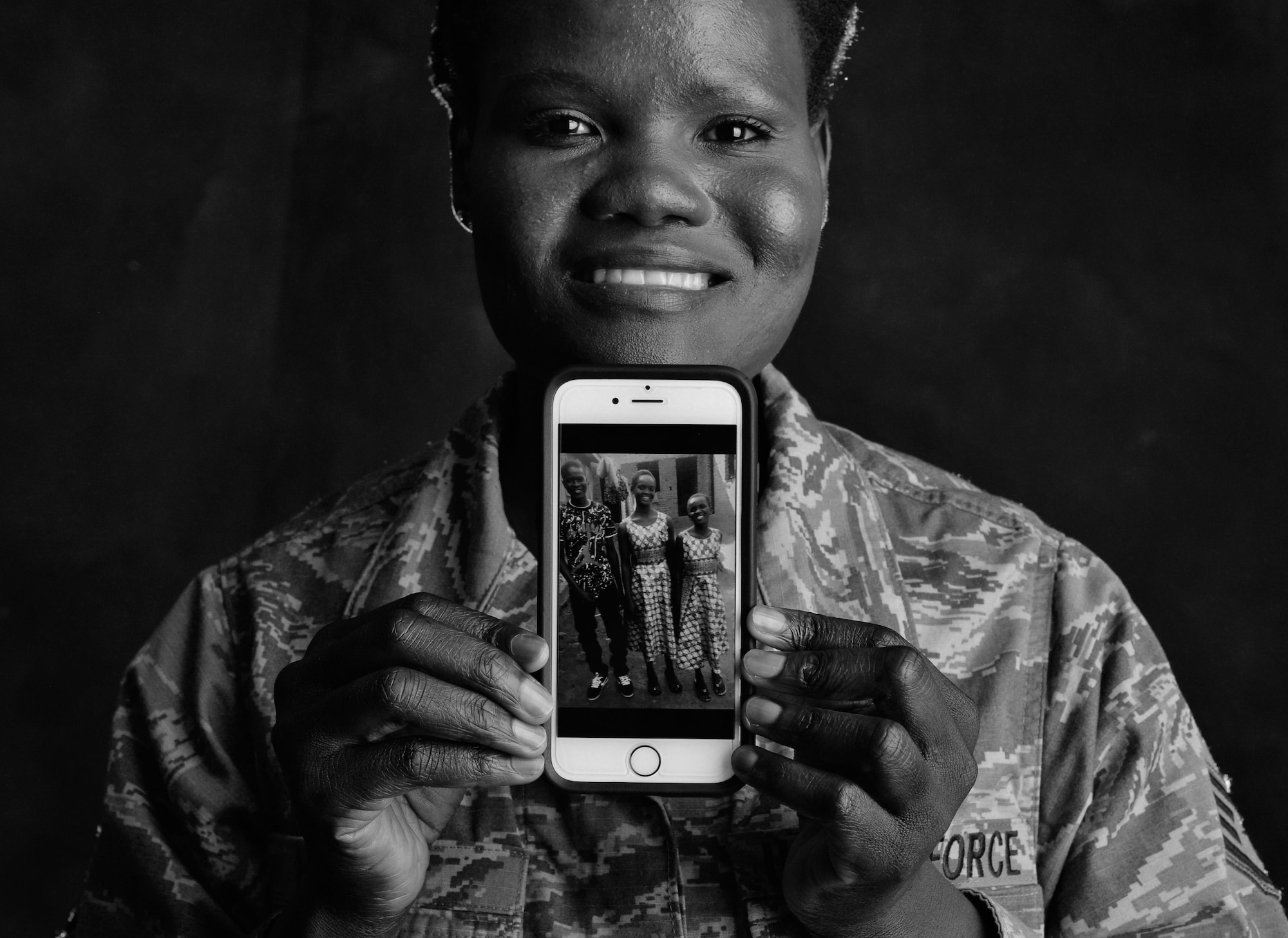 Staff Sgt. Martha Otto, a former South-Sudanese refugee, holds a photo of her nephew and nieces, whom, like Otto years ago, fled their civil war-torn country of South Sudan in search of safety from Joseph Kony’s Lord Resistance Army. The 86th Logistics Readiness Squadron training manager recently financially assisted her family out of a North Ugandan refugee camp and into boarding school and is passionate about sharing her story to help others. (U.S. Air Force photo by Staff Sgt. Nesha Humes)