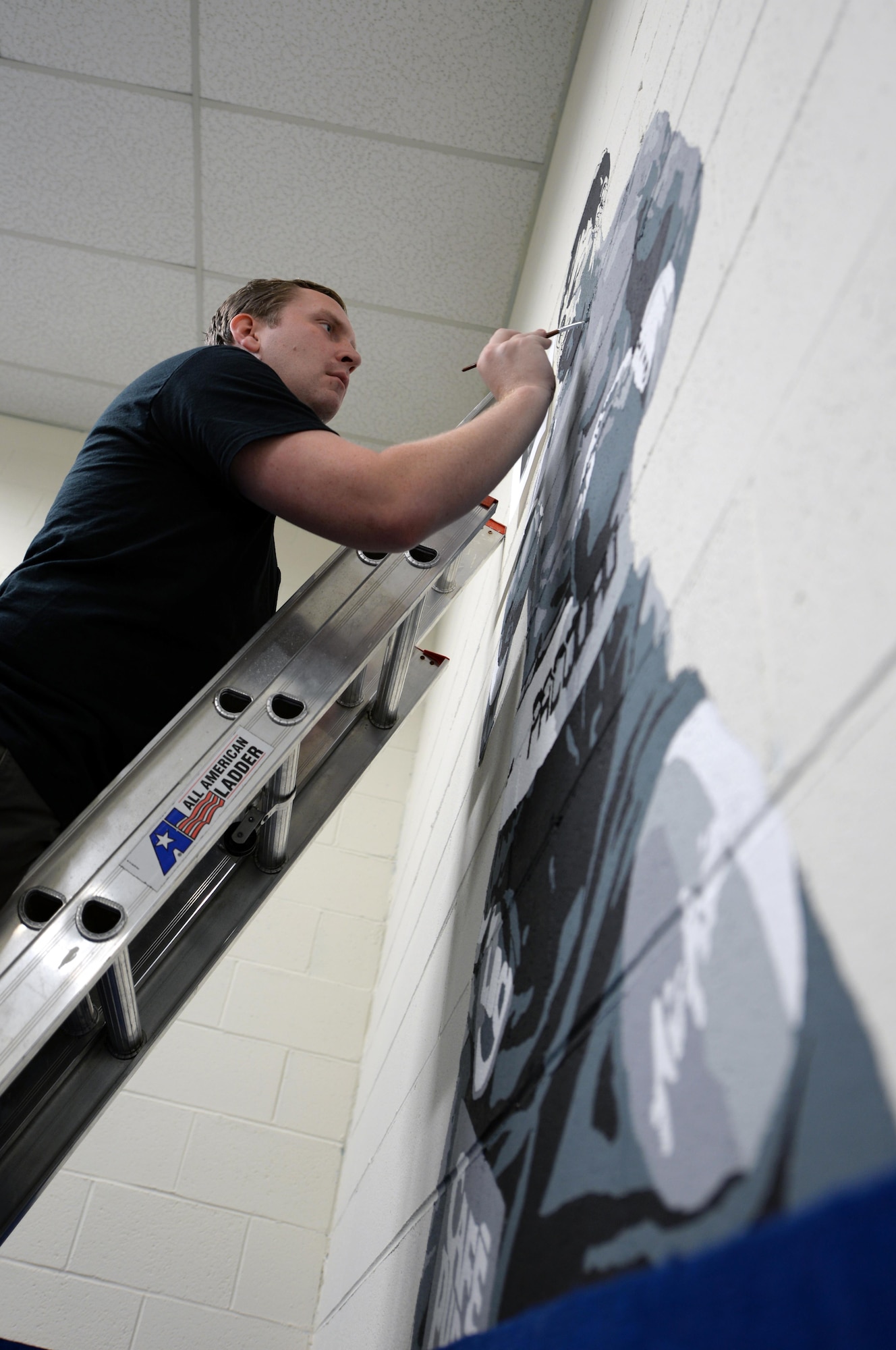Ian Mangum, 42nd Force Support Squadron Family Camp reservation specialist, paints a mural at the Gunter Air Force Base Gym, April 14, 2017. Mangum used more than five paints ranging from white to black. (U.S. Air Force photo/Senior Airman Tammie Ramsouer)