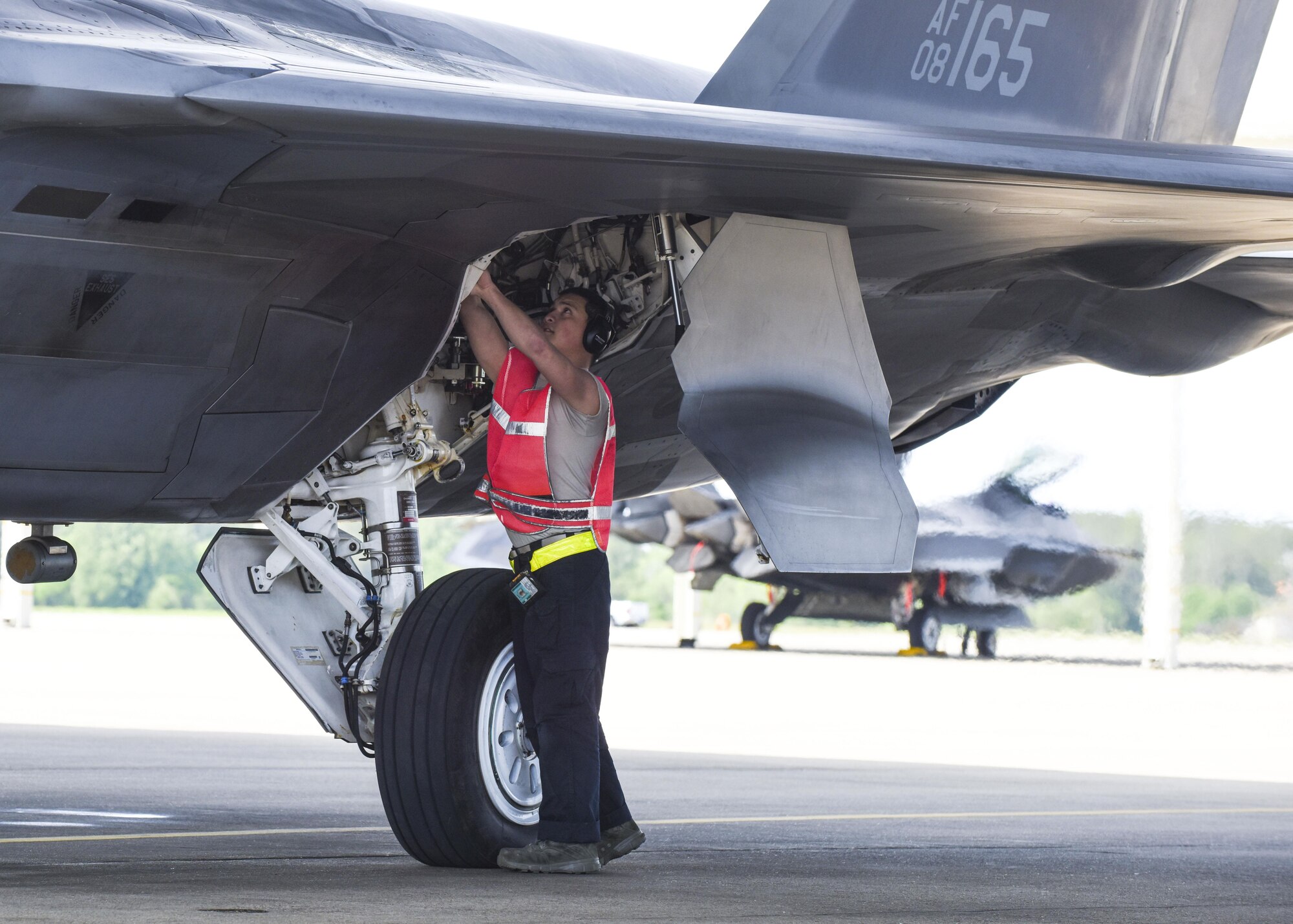 A U.S. Air Force crew chief from the 1st Maintenance Squadron, 27th Aircraft Maintenance Unit, performs a final inspection on an F-22 Raptor during ATLANTIC TRIDENT 17 at Joint Base Langley-Eustis, Va., April 18, 2017. The Raptor performs both air-to-air and air-to-ground missions, allowing full realization of operational concepts vital to the 21st century Air Force. (U.S. Air Force photo/Airman 1st Class Anthony Nin Leclerec)