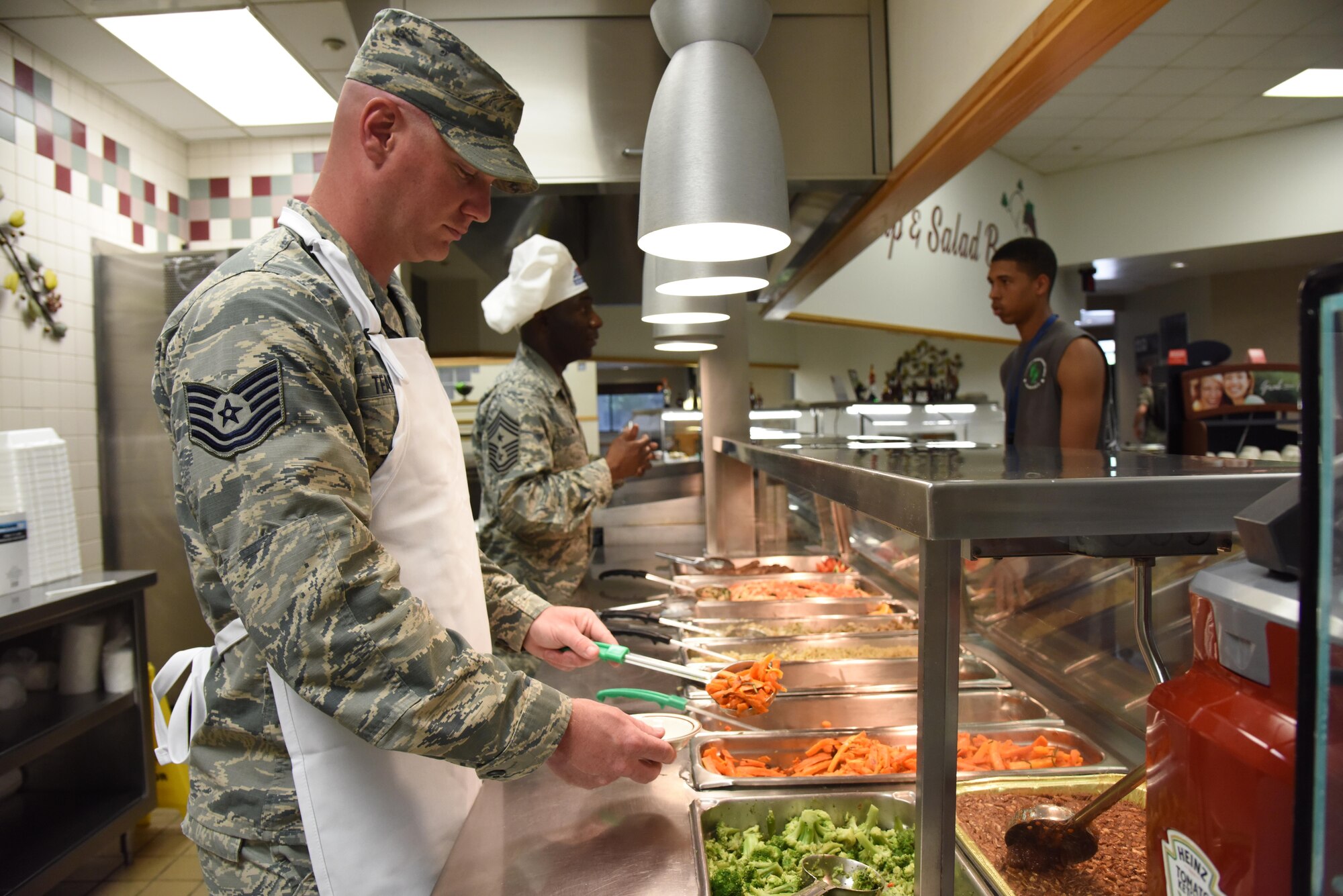 Tech. Sgt. Brian Teachout, 81st Logistics Readiness Squadron small air terminal NCO in charge, serves Airmen food at the Azalea Dining Facility April 11, 2017, on Keesler Air Force Base, Miss. He participated in the Command Chief for a Day program which highlights outstanding enlisted performers from around the wing. Each Airman selected for the program spends the day shadowing Chief Master Sgt. Vegas Clark, 81st Training Wing command chief, to learn what it takes to be a command chief. (U.S. Air Force photo by Kemberly Groue)