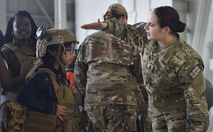 First Lt. Meredith Mulvihill, 1st Combat Camera Squadron, helps a 5th-grade student from Sedgefield Intermediate School don individual protective equipment as part of a career day event at Joint Base Charleston, S.C., April 20, 2017. The students talked to Airmen and participated in various career field specific demonstrations alongside subject matter experts from various units on the installation. Junior Reserve Officer Training Corps members from Fort Dorchester High School, Orangeburg Wilkinson High School, Summerville High School and Military Magnet Academy were also attended the event.