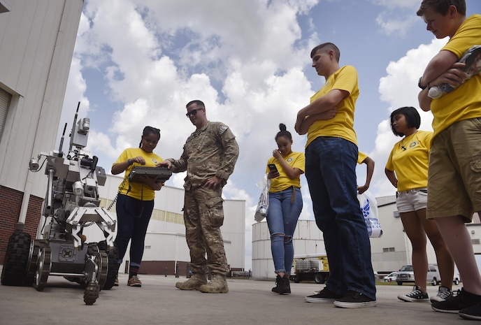 Staff Sgt. Joshua Rickert, center left, 628th Civil Engineer Squadron explosive ordinance, disposal, shows Junior Reserve Officer Training Corps members, Summerville High School, the basics of operating an F6A robot as part of a career day event at Joint Base Charleston, S.C., April 20, 2017. The JROTC members talked to Airmen and participated in various career field specific demonstrations alongside subject matter experts from various units on the installation. Fifth grade students from Sedgefield Intermediate School also attended the event. 