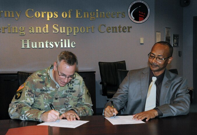 Col. John S. Hurley, commander U.S. Army Engineering Center, Huntsville and Abner Merriweather, president of AFGE Local 1858, place their signatures on Huntsville Center’s first collective bargaining agreement April 13.