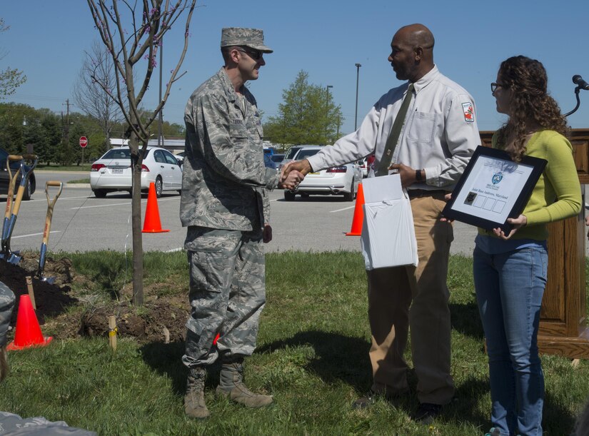 Col. E. John Teichert, 11th Wing and Joint Base Andrews commander, receives awards at a ceremony on base April 18, 2017, from Horace Henry, Maryland Department of Natural Resources representative, in honor of Earth Week and Arbor Day, for the base’s contributions to environmental services. The week also included base cleanups, seed planting, a youth art display and more. (U.S. Air Force photo by Senior Airman Mariah Haddenham) 
