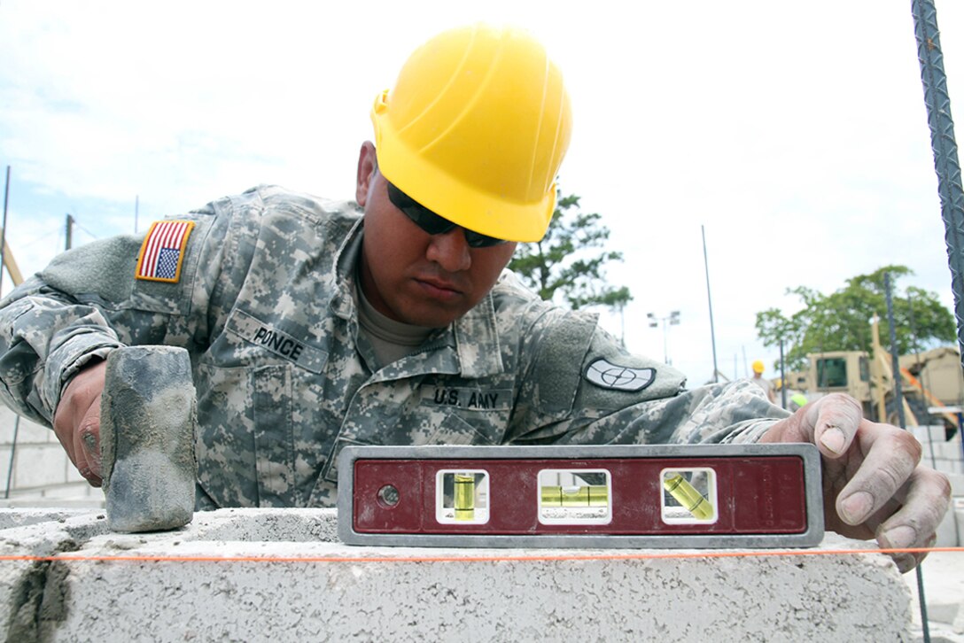 Pfc. Alfredo Ponce, a carpenter with the 808th Engineer Company, levels a cinder block on the foundation of a new medical clinic April 15, 2017, during a construction project at Double Head Cabbage, Belize as part of Beyond the Horizon 2017.  The construction project is one of five scheduled for Beyond the Horizon 2017, a U.S. Southern Command-sponsored, Army South-led exercise designed to provide humanitarian and engineering services to local communities in Belize. (U.S. Army Photo by Staff Sgt. Fredrick Varney, 131st Mobile Public Affairs Detachment)