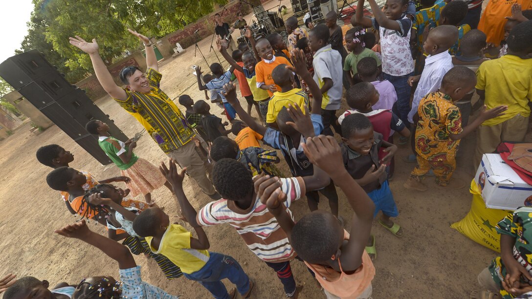 Air Force Col. Ric Trimillos dances with children during a performance by Touch 'n Go, the U.S. Air Forces in Europe popular music ensemble, at the Save Our Souls Children's Village in Ouagadougou, Burkina Faso, April 19, 2017. The band’s visit supported African Partnership Flight, a workshop for U.S. and African partner nations to enhance aviation capacity and collaboration. Air Force photo by Staff Sgt. Jonathan Snyder