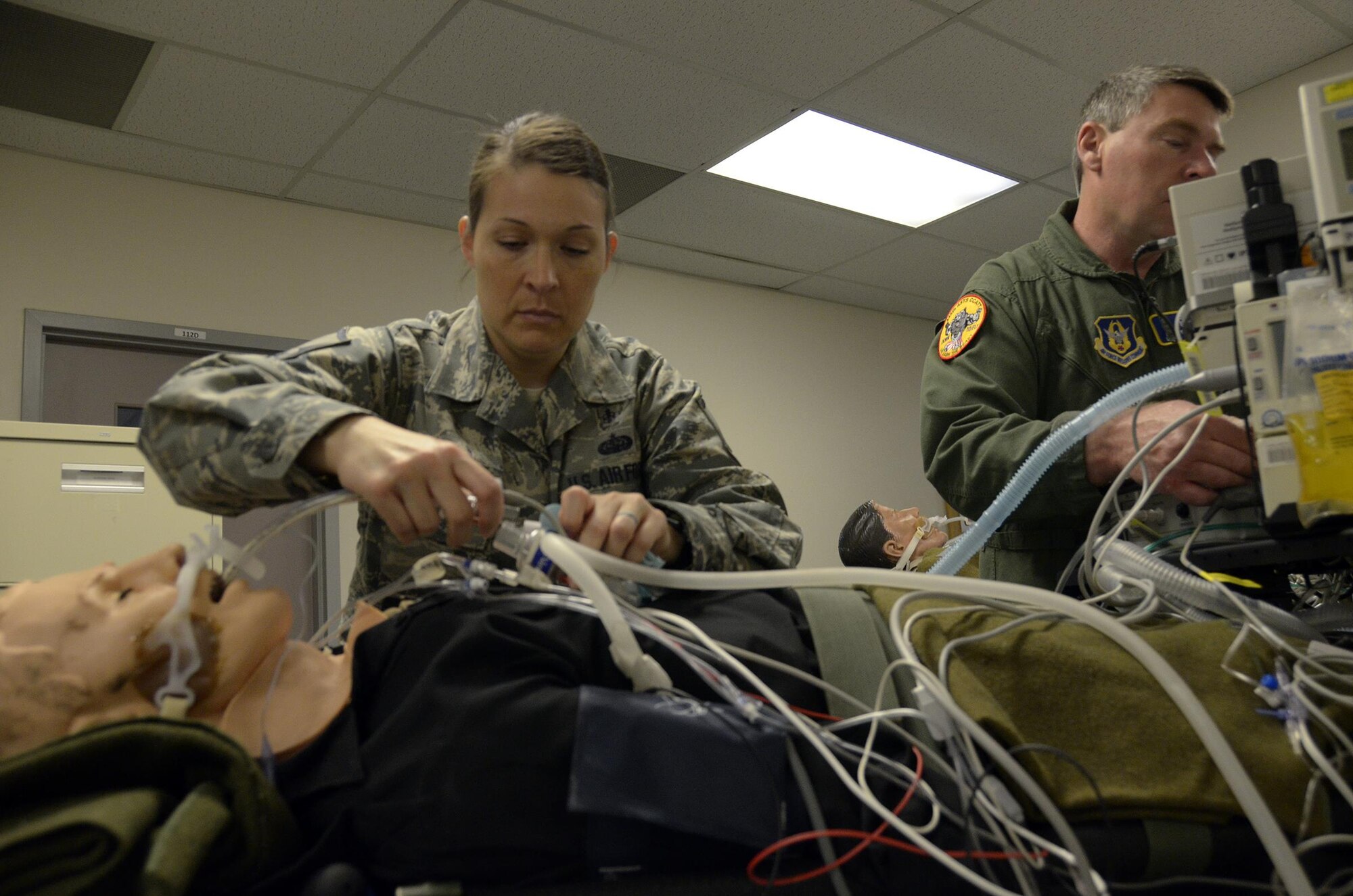 Master Sgts. Jamie Sherman and Larry Combs, both assigned to the respiratory section of the Critical Care Air Transport Team, 445th Aeromedical Staging Squadron, prepare a notional patient for transportation during a home station exercise on April 1, 2017. The two members tape down cables and tubes to make sure patients are easily and safely transported. (U.S. Air Force photo/Staff Sgt. Joel McCullough)