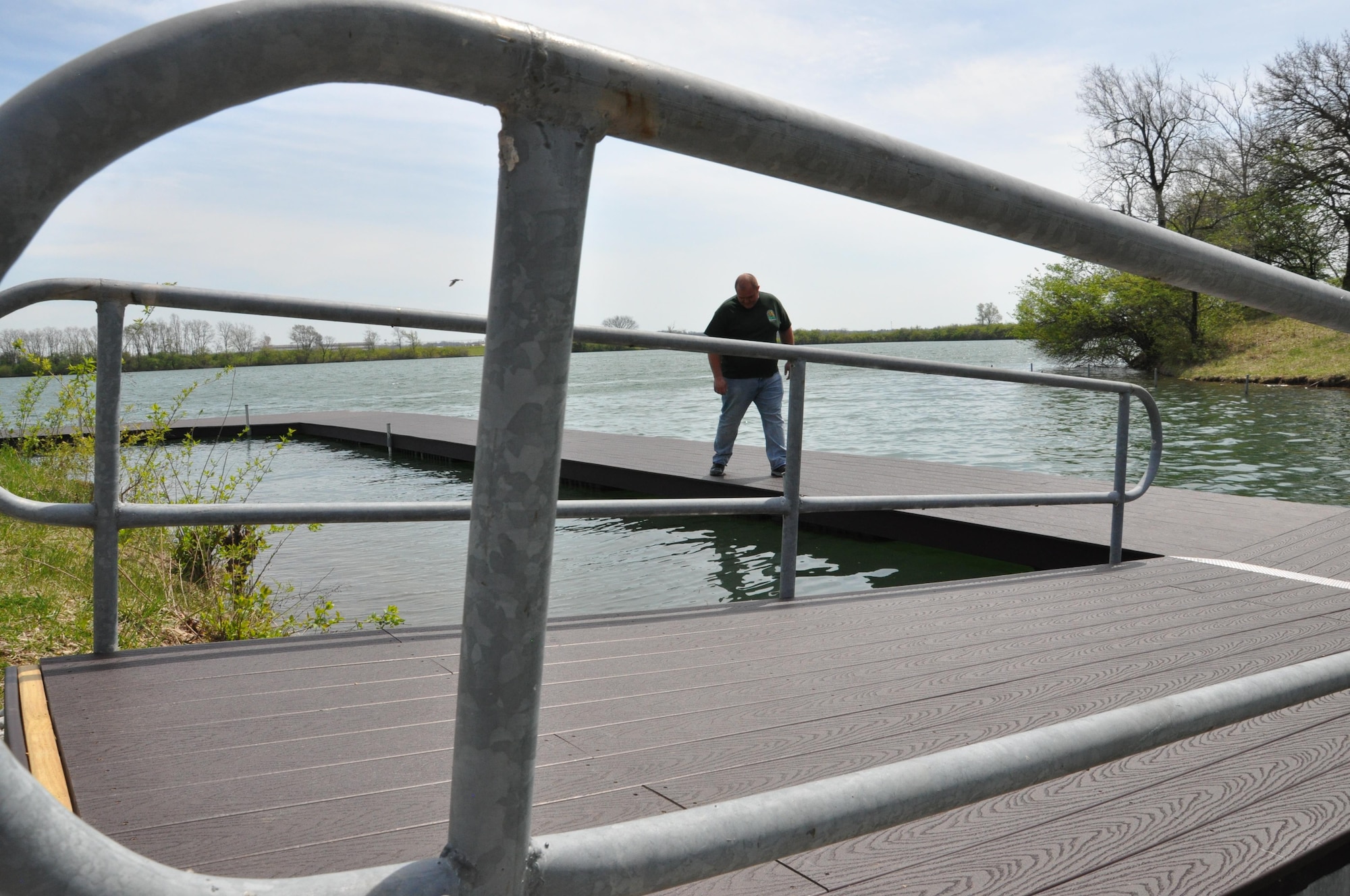 Brandon Dixon, Outdoor Recreation Manager, Community Services Flight, 88th Force Support Squadron, inspects the dock at the Bass Lake Recreational Facility at Wright-Patterson Air Force Base April 10, 2017. The dock required extensive repairs to meet safety requirements, including securing it to the bank, replacing planking and adding flotation devices. The dock, which was closed in November 2016 to begin the repairs, is scheduled to reopen mid-to-late summer after the last of the flotation equipment is installed and tested. (U.S. Air Force photo/Jim Mitchell)