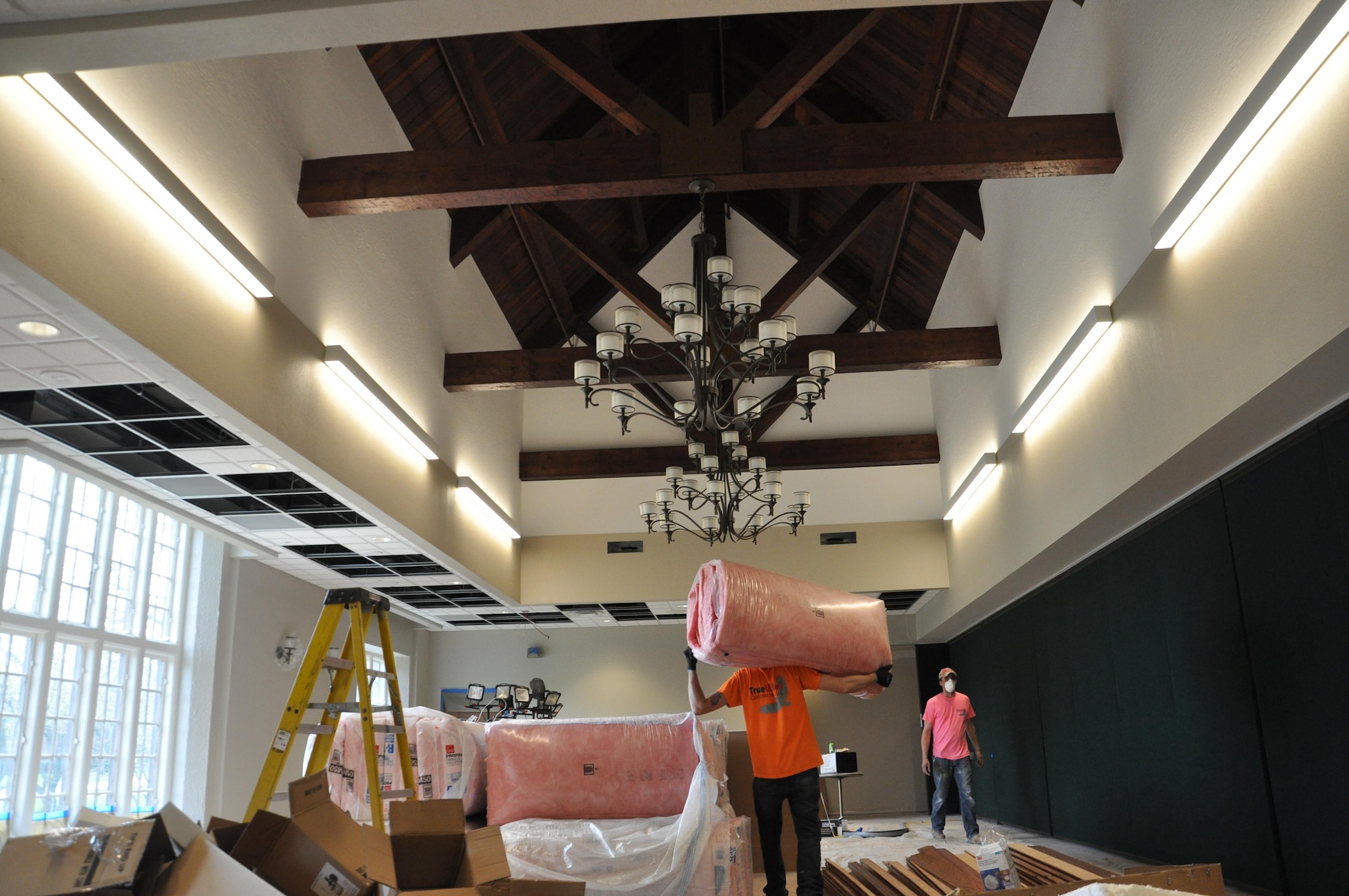 Construction workers move insulation in the Daedallion Room at the Wright-Patterson Club on April 10, 2017. During renovations, workers found wooden crossbeams that were part of the original construction of the club in the 1920s. Construction was halted after the find, and it was found they were structurally sound and could remain exposed.  The beams only required oiling to return them to their original state. Era-appropriate chandeliers were installed to make this the centerpiece of the room. The Daedallion, main ballroom and the Bicycle Room, which closed for renovations in December 2016, are all scheduled to reopen in late May 2017.  (U.S. Air Force photo/Jim Mitchell)