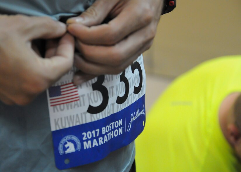 A Boston Marathon Shadow Run participant attaches his official bib number before the race, April 17, Camp Arifjan, Kuwait. This is the first time Camp Arifjan has hosted a Boston Marathon Shadow Run and it gave many deployed personnel, regardless of country, an opportunity to participate in this famous event.  (U.S. Army photo by Sgt. Kimberly Browne, USARCENT Public Affairs)