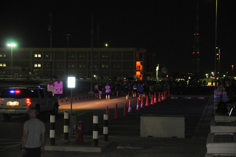 A Military Police vehicle follows participants of Camp Arifjan’s first Boston Marathon Shadow Run, April 17, Camp Arifjan, Kuwait. This race shadowed the 121st Boston Marathon, and gave deployed personnel an opportunity to run in the famous marathon. More than 300 people participated in the shadow run.  (U.S. Army photo by Sgt. Kimberly Browne, USARCENT Public Affairs)