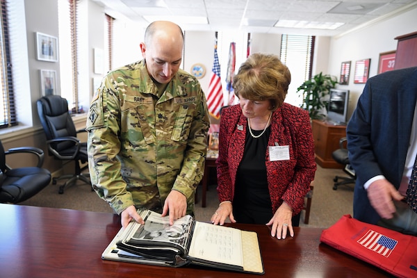 U.S. Army Corps of Engineers, Mobile District, Deputy Commander Lt. Col. Landon Raby presents a book to Barbara R. McLauchlin, the daughter of Maj. Gen. Daniel A. Raymond, April 20. Raymond himself put the book together of key milestones of the district during his command here from 1961-1964. 