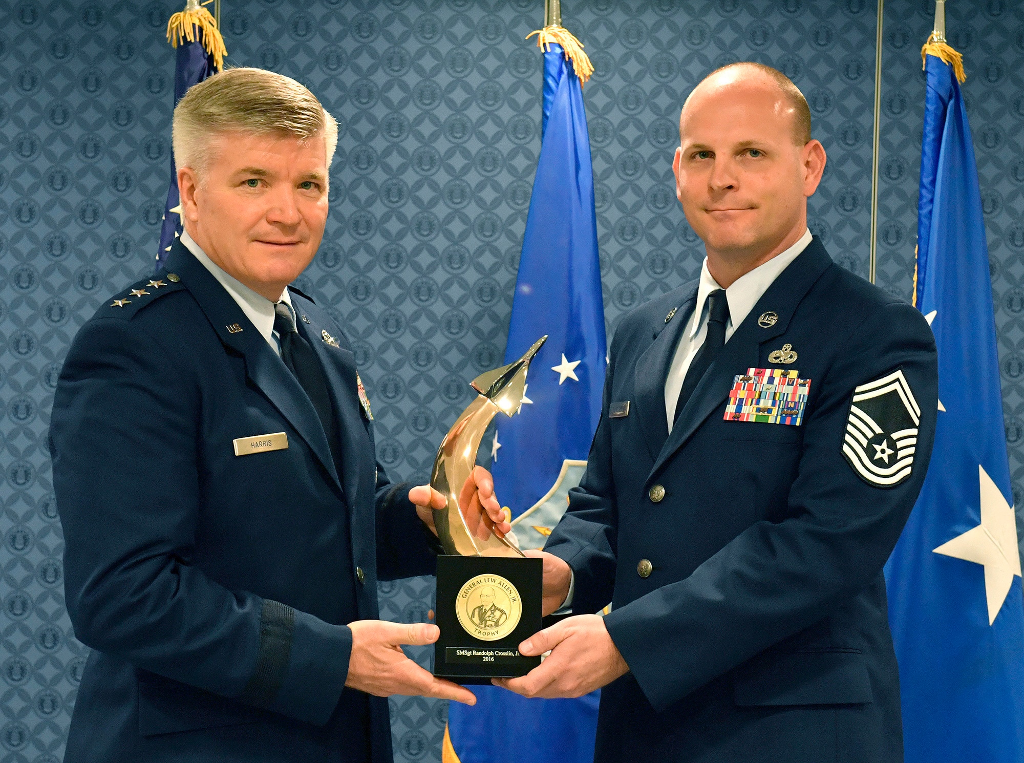 Lt. Gen. Jerry Harris, the deputy chief of staff for strategic plans, programs and requirements, presents Senior Master Sgt. Randolph Crosslin Jr. the Gen. Lew Allen Jr. Trophy for 2016, during a ceremony at the Pentagon, April 21, 2017. (U.S. Air Force photo/Wayne A. Clark)