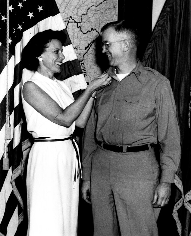 Barbara Raymond pins the rank of colonel on her husband, Lt. Col. Daniel A. Raymond, who was then the Mobile District Commander.