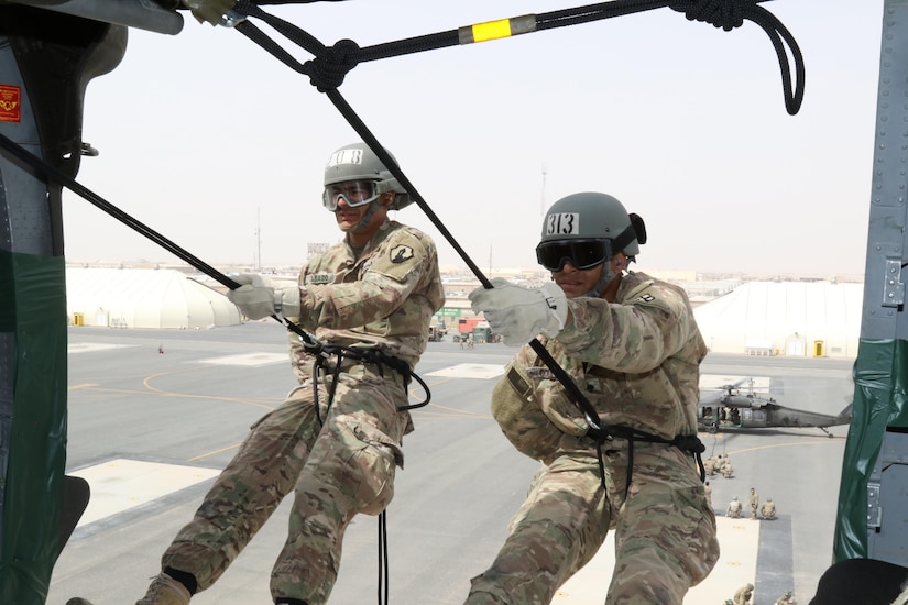 U.S. Army Spc. Melendez Casado (left), horizontal construction engineer, 176th Engineer Brigade, and Army Spc. Elijah Gould (right), pharmacy specialist, 3rd Medical Command Deployment Support, prepare to rappel out of a UH-60 Black Hawk helicopter during U.S. Army Central’s first Air Assault Course, April 13, 2017, at Camp Beuhring, Kuwait. The Air Assault Course is a 12-day class that allows U.S. military personnel in the U.S. Army Central area of operations the unique opportunity to become air assault qualified, while deployed outside the continental United States.