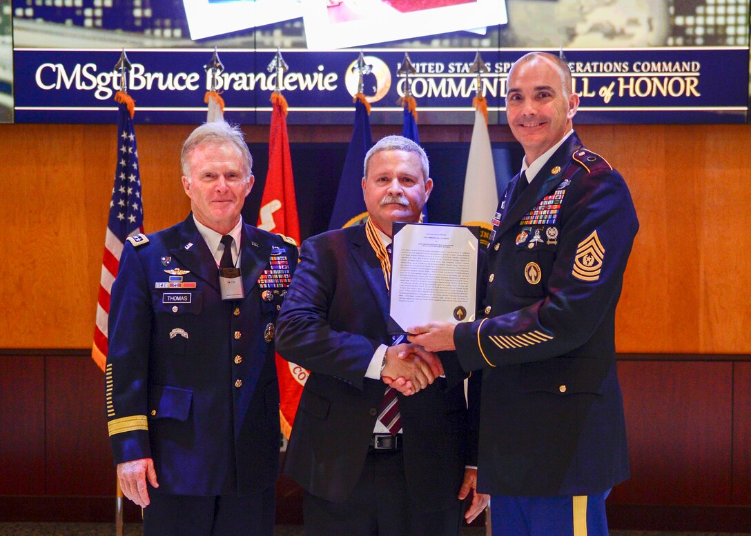 Army Gen. Raymond A. Thomas, USSOCOM commander, and Command Sgt. Maj. Patrick L. McCauley, USSOCOM command senior enlisted adviser recognizes Chief Master Sgt. Bruce Brandewie during the 2017 Commando Hall of Honor Ceremony located at the USSOCOM headquarters, MacDill Air Force Base, Florida, April 18.  CMSgt  Brandewie embody the skills, values, spirit and courage of a Special Operations Forces Warrior and was one of the seven inductees that were honored during this ceremony.  