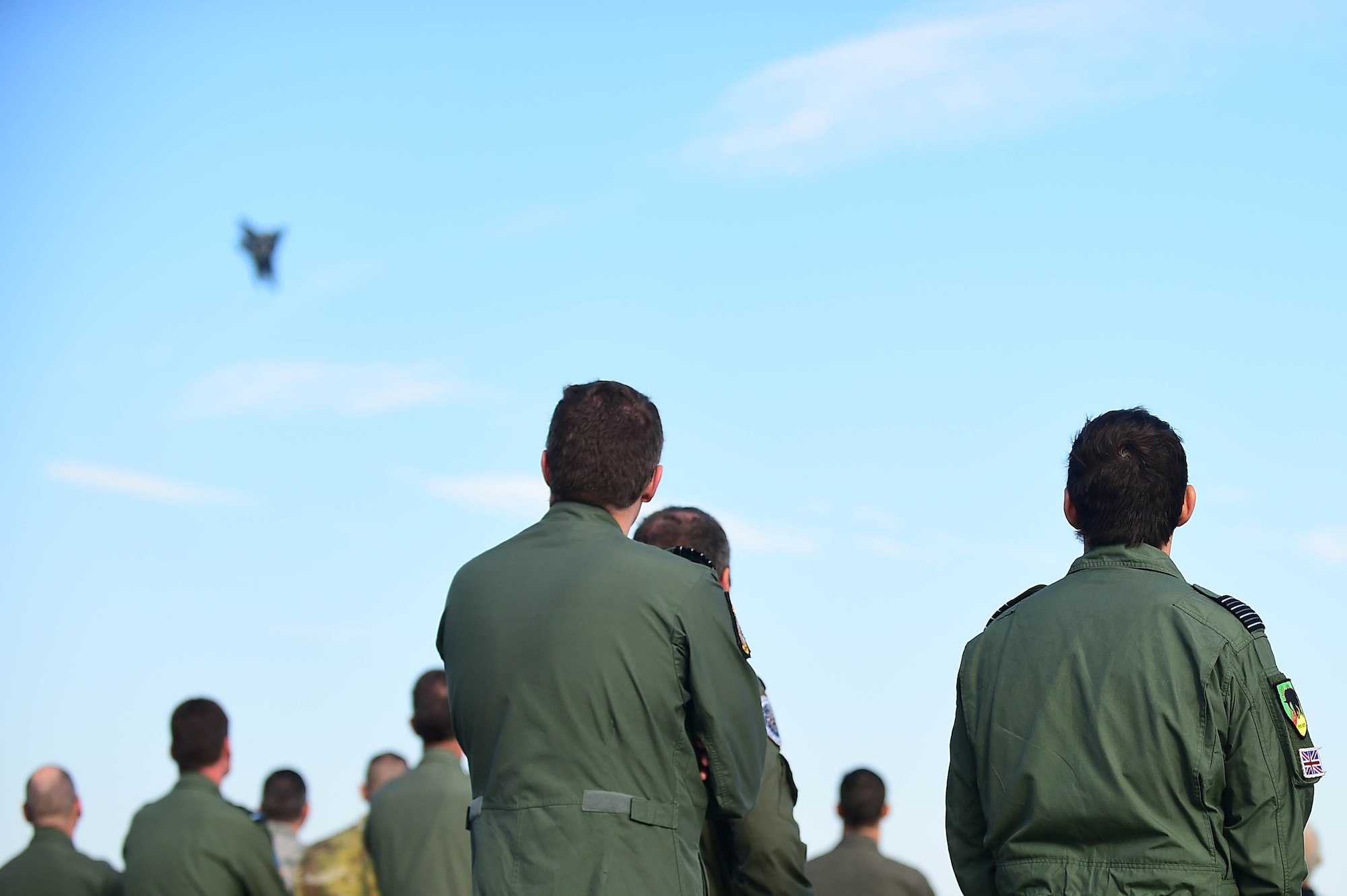 Participants in the ATLANTIC TRIDENT 17 observe the F-22 Raptor Demonstration at Joint Base Langley-Eustis, Va., April 21, 2017. The Raptor was one of three acts during the World War I Remembrance Day, including the French air force Dassault Rafale and the Patrouille de France. (U.S. Air Force photo/Senior Airman Kimberly Nagle)