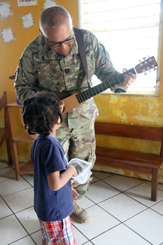 Capt. Julio Vargas, a chaplain with the 448th Engineer Battalion, plays a guitar for the children at Liberty Children's Home April 18, 2017, during a community relations event held in Ladyville, Belize as part of Beyond the Horizon 2017.  Servicemembers helped to clear debris from the property, played games and sang songs with the home’s children during the event. BTH 2017 is a partnership exercise between the Government of Belize and U.S. Southern Command that will provide three free medical service events and five construction projects throughout the country of Belize from March 25 until June 17. (U.S. Army Photo by Staff Sgt. Fredrick Varney)