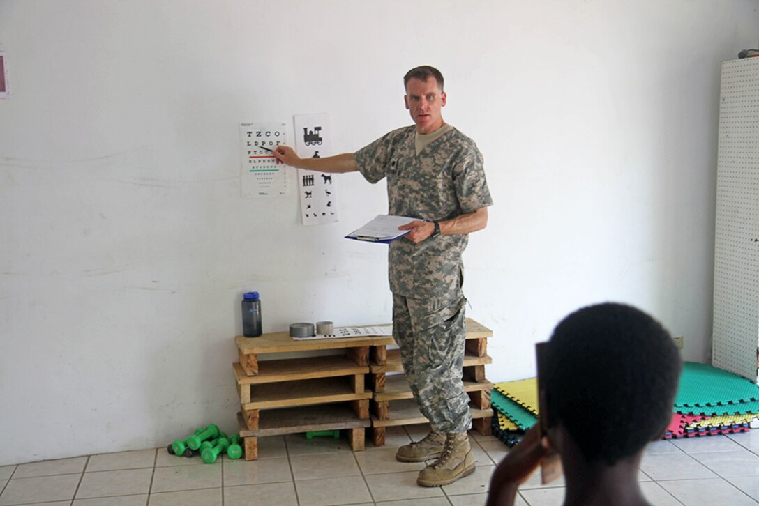 Lt. Col. Peter Stewart, a case management nurse with the Utah Medical Command, conducts an eye exam for a young patient at Liberty Children's Home April 18, 2017, during a community relations event held in Ladyville, Belize as part of Beyond the Horizon 2017.  BTH 2017 is a U.S. Southern Command-sponsored, Army South-led exercise designed to provide humanitarian and engineering services to communities in need, demonstrating U.S. support for Belize.(U.S. Army Photo by Staff Sgt. Fredrick Varney)