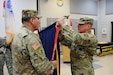 Maj. Gen. Troy D. Kok, commanding general of the U.S. Army Reserve’s 99th Regional Support Command (right), and Command Sgt. Maj. Al Almeida, 99th RSC command sergeant major, affix the Army Superior Unit Award streamer to the 99th RSC Colors during a ceremony April 21 at the command’s headquarters on Joint Base McGuire-Dix-Lakehurst, New Jersey. The 99th RSC received the award for providing aid and assistance from October 2012 to April 2013 to communities in New York City that were devastated by Superstorm Sandy.