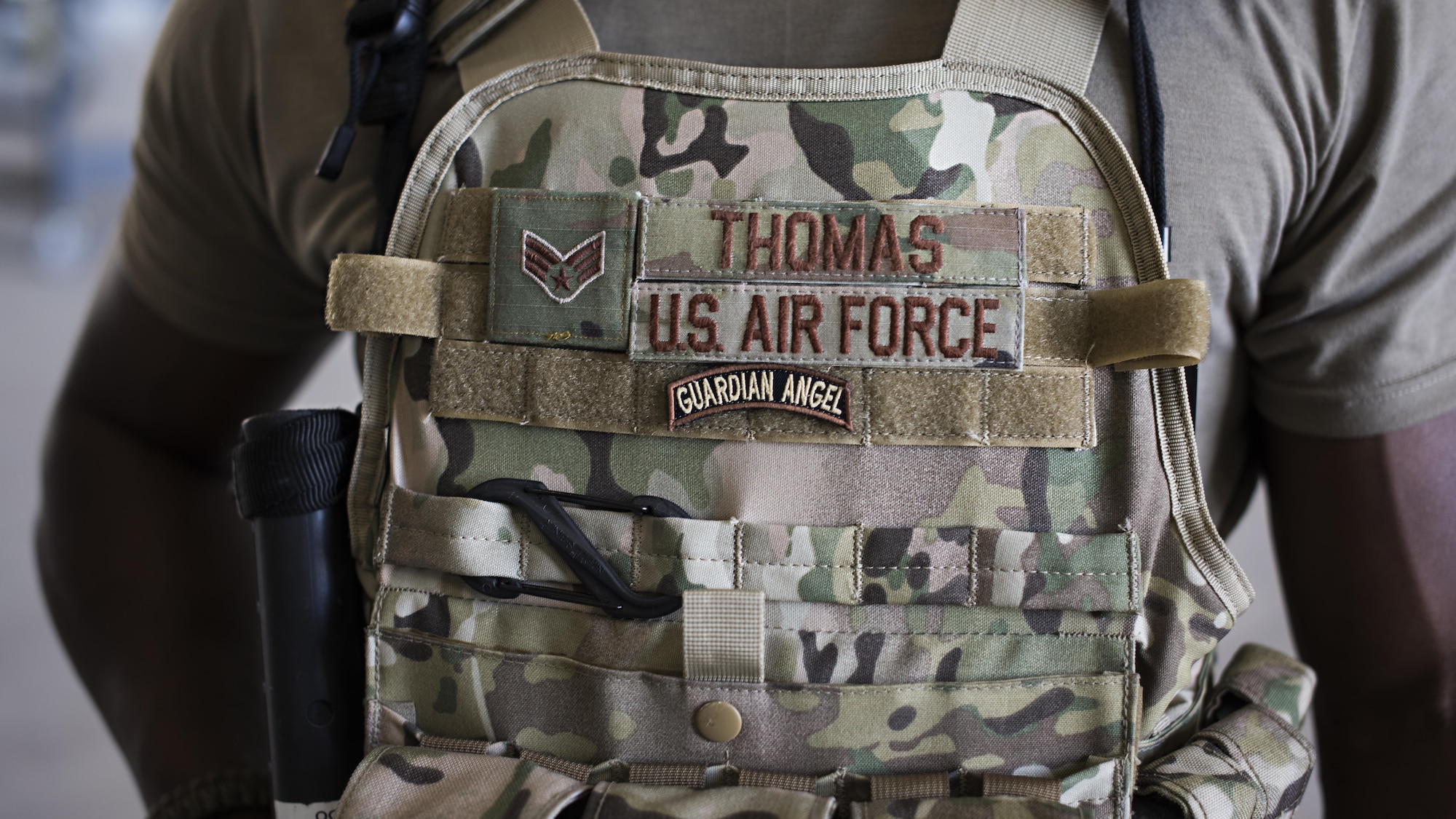 Senior Airman Micheal Thomas, 738th Air Expeditionary Advisory Group guardian angel, provides armed overwatch for contractors and air advisors performing maintenance on an Afghan Air Force MD-530 Light Attack Helicopter, April 16, 2017, at Kandahar Air Wing, Afghanistan. The deployed members of the 507th Security Forces Squadron team wear the guardian angel patch in this role. (U.S. Air Force photo/Staff Sgt. Katherine Spessa)