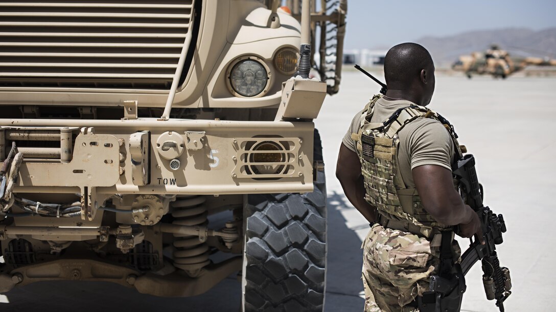 Senior Airman Micheal Thomas, 738th Air Expeditionary Advisory Group guardian angel, provides armed overwatch for contractors and air advisors performing maintenance on an Afghan Air Force Mi-17 Military Transport Helicopter, April 16, 2017, at Kandahar Air Wing, Afghanistan. Thomas is deployed with other Citizen Airmen from the 507th Security Forces Squadron, Tinker Air Force Base, Okla. (U.S. Air Force photo/Staff Sgt. Katherine Spessa)