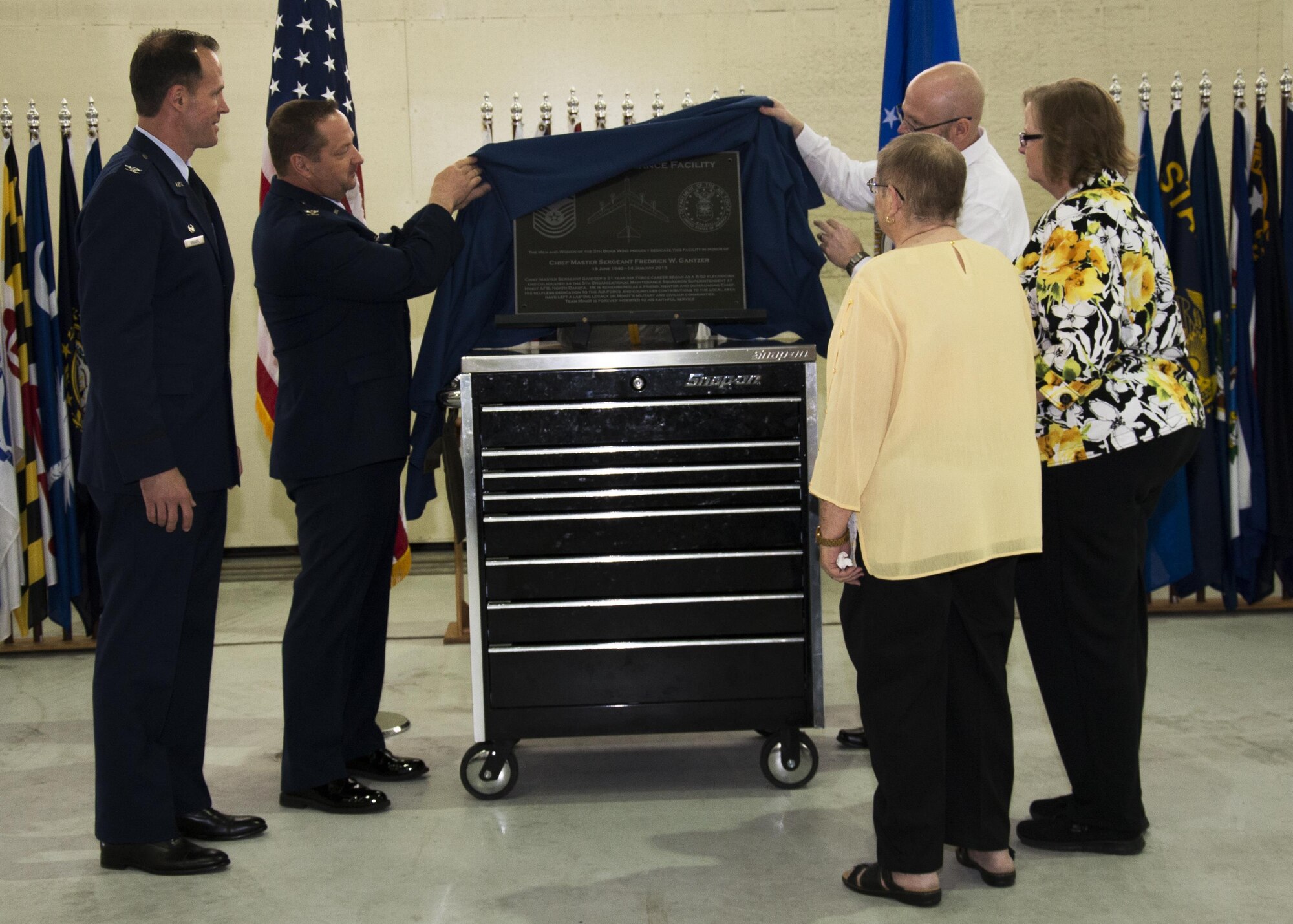 (From left) Col. Matthew Brooks, 5th Bomb Wing commander, Col. Thomas Kirkham, 5th Maintenance Group commander, and the Gantzer family unveil the dedication plaque during a ceremony at the Gantzer Maintenance Facility at Minot Air Force Base, N.D., April 21, 2017. Chief Master Sgt. Fredrick Gantzer was honored for his dedication, hard work and consistence in supporting the base and the community while serving at Minot AFB. (U.S. Air Force photo/Airman 1st Class Alyssa M. Akers)