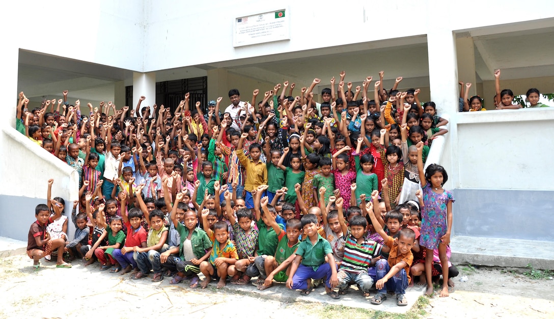 Managed by the U.S. Army Corps of Engineers – Alaska District’s Asia Office, final construction operations are wrapping up the three-year Multipurpose Cyclone Shelter and School Program with the financial assistance from U.S. Agency for International Development. Shown here, students show their school spirit at one of the newly constructed facilities.