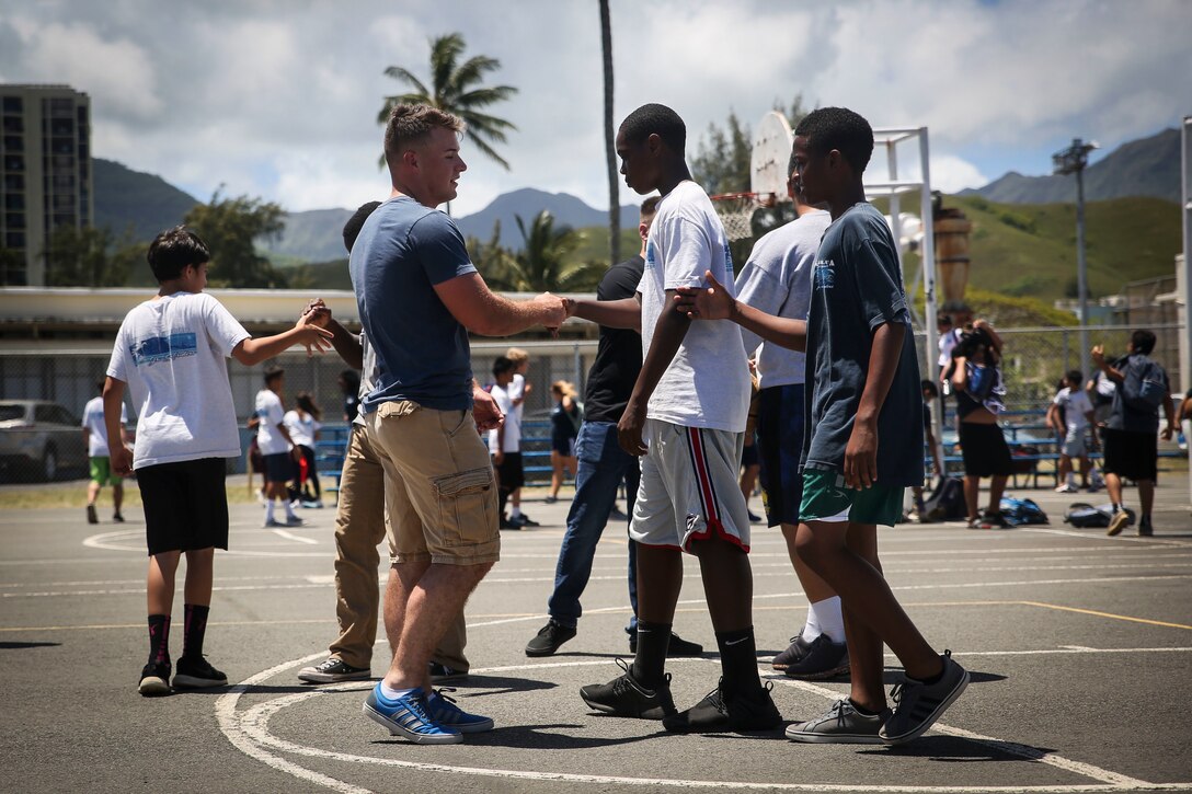 KAILUA, Hawaii – Lance Cpl. Malsky Kennan, a ground electronics telecommunications and information technology systems maintainer with Headquarters Battalion, Marine Corps Base Hawaii, congratulates students after a basketball game at Kailua Intermediate School, April 12, 2017. Marines gave back to their community by volunteering at KIS for the school’s “Wednesday Volunteer Program.” The program provides Marines the opportunity to interact with students, assist teachers around the classroom, and be positive role models for the children. (U.S. Marine Corps Photo by Cpl. Jesus Sepulveda Torres)