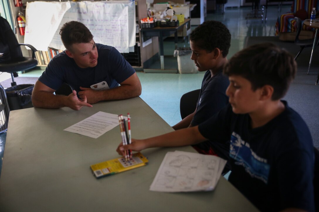 KAILUA, Hawaii – Lance Cpl. Malsky Kennan, a ground electronics telecommunications and information technology systems maintainer with Headquarters Battalion, Marine Corps Base Hawaii, assists students with classwork at Kailua Intermediate School, April 12, 2017. Marines gave back to their community by volunteering at KIS for the school’s “Wednesday Volunteer Program.” The program provides Marines the opportunity to interact with students, assist teachers around the classroom, and be positive role models for the children. (U.S. Marine Corps Photo by Cpl. Jesus Sepulveda Torres)