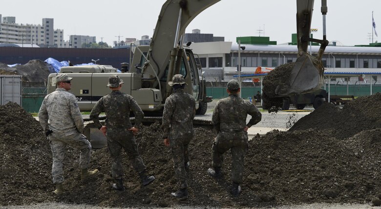 U.S. and Republic of Korea Airmen watch an excavator during the U.S./ROK Combined Airfield Damage Repair Exercise at Daegu Air Base, April 18, 2017. For five days, U.S. and ROK Airmen repaired damaged runway sections while sharing techniques, strengthening bonds and forging friendships between the two allied countries. (U.S. Air Force photo by Staff Sgt. Alex Fox Echols III)